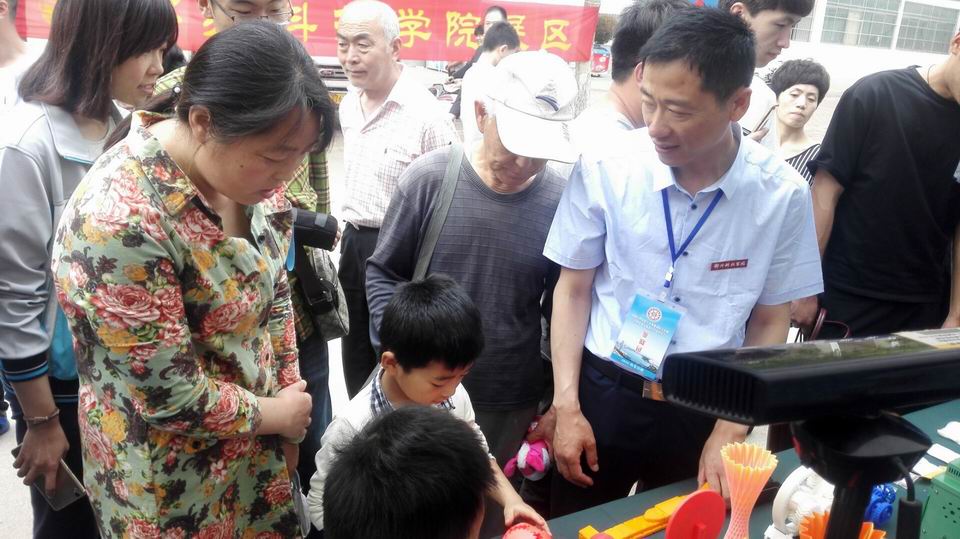 6我校实践教学中心王自寻书记向观众介绍参展情况.jpg
